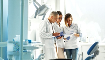 A dentist and staff members discussing