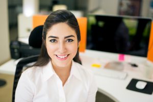 Smiling young woman at desk