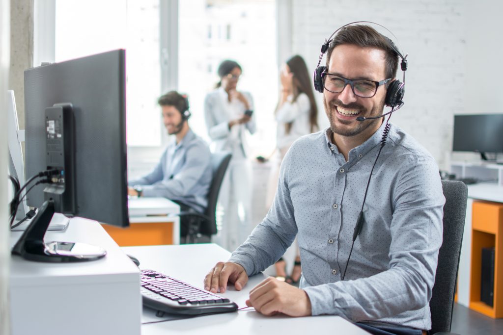 Laughing man in office with phone headset.
