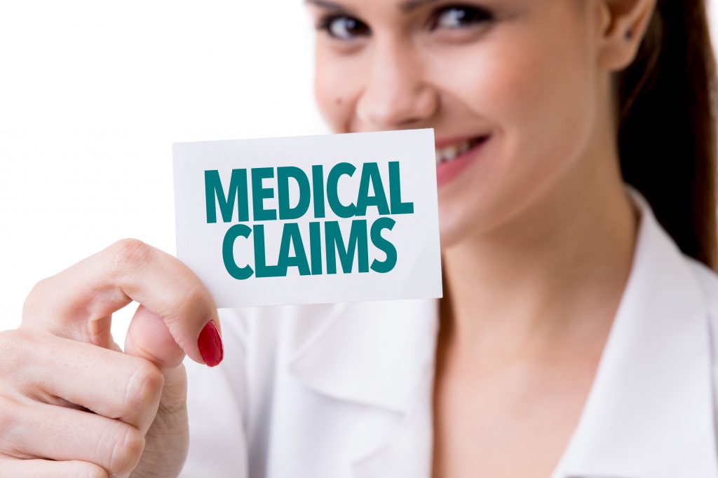 Woman holding up a card reading medical claims