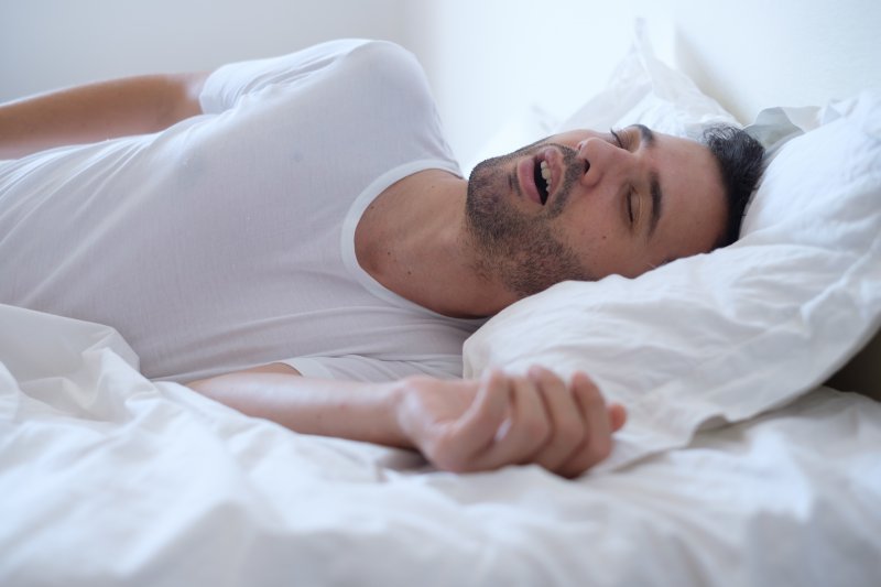 a young man asleep with his mouth open and in need of a sleep dentist