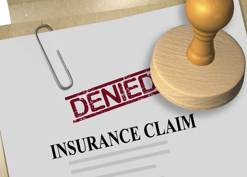 Animated image of a “Denied” stamp sitting on an insurance claim 